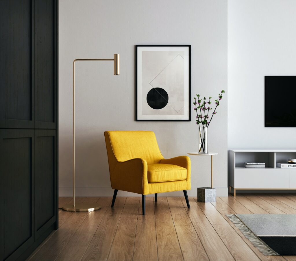 A yellow chair below a minimalist painting.